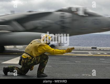 Stati Uniti Navy Petty Officer 1. Classe Michael Quintos lancia un AV-8B Harrier aeromobile durante il volo fuori del Marine squadrone di attacco 211, 31 Marine Expeditionary Unit dal ponte di volo dell'assalto anfibio nave USS Essex (LHD 2) nel Mare delle Filippine il 10 agosto, 2009. Foto Stock