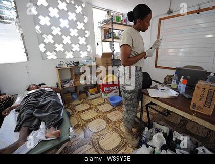 Stati Uniti Air Force Lt. Jena Campbell, attaccato all'elemento medico Joint Task Force Bravo, fornisce cure mediche per un terremoto superstite presso una clinica in Killick, Haiti, a gennaio 30, 2010. Joint Task Force Bravo è il supporto di funzionamento risposta unificata fornendo il supporto militare alle autorità civili per contribuire a stabilizzare e migliorare la situazione nella nazione insulare. Foto Stock