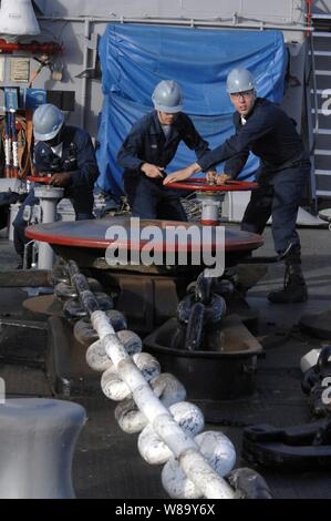 Stati Uniti Navy Petty Officer di terza classe Ryan McLaughlin (sinistra), marinaio Garrett Mann e il Marinaio Michael Campana (a destra) il controllo del verricello salpa ancora mentre cadono ancora a bordo il trasporto anfibio dock nave USS Cleveland (LPD 7) durante l'Orlo del Pacifico, una biennale, multinazionale esercizio inteso a rafforzare i partenariati regionali e migliorare l'interoperabilità multinazionale a Honolulu il 24 giugno 2010. Foto Stock