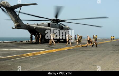 Stati Uniti Marines prepararsi a bordo di un CH-53E Super Stallion elicottero assegnato ad elicottero medio marino Squadron 165 a bordo della USS Peleliu (LHA 5) nel Mare Arabico per supportare quelle che forniscono aiuti umanitari per aree allagate del Pakistan sul mese di agosto 12, 2010. Foto Stock