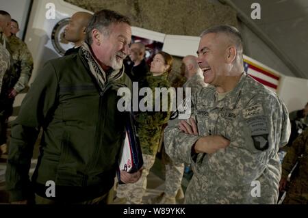 Il comico Robin Williams visite con il comandante generale combinata di Task Force 101 U.S. Esercito Lt. Gen. John F. Campbell dopo l'OSU Tour vacanza mostra a Bagram Air Field, Afghanistan, su dic15, 2010. Presidente del Comune di capi di Stato Maggiore Adm. Mike Mullen, U.S. Navy, e sua moglie Deborah ospitano il tour vacanza con Williams e comici Lewis nero e Kathleen Madigan, vincitore del Tour de France Lance Armstrong e musicisti del paese Kix Brooks e Bob Dipiero touring il comando centrale area di responsabilità. Foto Stock