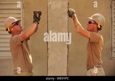 Stati Uniti Navy Petty Officer Robert DeLuca (sinistra) e Sottufficiali Naethan Clark, entrambi assegnati alla Naval Mobile Battaglione di costruzione 74, Dettaglio Corno d Africa, applicare lo stucco per un schoolhouse progetto di costruzione a Gibuti il Gen 12, 2011. L'unità dispiegato per Combined Joint Task Force-Horn dell Africa per aiutare nella costruzione della nazione ospite di partenariati e di promuovere la stabilità regionale in tutta la regione. Foto Stock