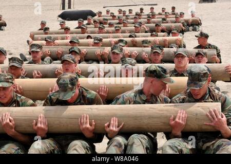 Prima fase di base demolizioni subacquee/guarnizioni (BUD/S) candidati utilizzare il lavoro di squadra per eseguire la formazione fisica esercita con 600 libbra di accedere a Naval Amphibious Base Coronado il 6 aprile 2011. Registro di allenamento fisico esercizi sono uno dei tanti fisicamente molto impegnativo evoluzioni che fanno parte della prima fase della formazione a BUD/S. I Navy SEALs sono il componente marittima degli Stati Uniti Forze per le operazioni speciali e sono addestrati per condurre una serie di operazioni dal mare, l aria e la terra. Foto Stock