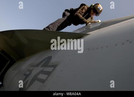 Stati Uniti Navy Seaman Bryan Domingue, assegnato a Strike Fighter Squadron 22, pulisce la tettoia su di un F/A-18F Super Hornet aeromobile a bordo della portaerei USS Carl Vinson (CVN 70) NEGLI STATI UNITI Quinta Flotta area di responsabilità il 23 aprile 2011. La Carl Vinson e Carrier aria Wing 17 sono state conducendo le operazioni di sicurezza marittima e di aria vicino le missioni di sostegno. Foto Stock