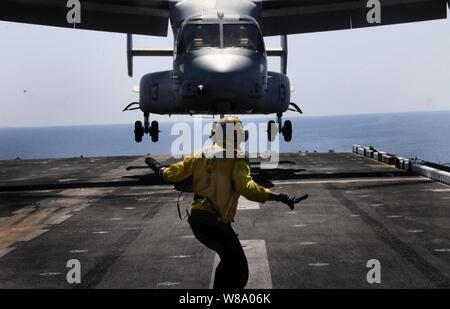 Un segnale di atterraggio arruolato assegnato al multipurpose Amphibious Assault nave USS Bataan (LHD 5) guide una MV-22B Osprey assegnato a mezzo marino Tiltrotor Squadron 263 (rinforzato), 22 Marine Expeditionary Unit, sul ponte di volo in corso nel Mar Mediterraneo il 16 maggio 2011. Il Bataan è la nave di comando di Bataan anfibio gruppo pronto e sta conducendo le operazioni di sicurezza marittima e di teatro la cooperazione in materia di sicurezza gli sforzi negli Stati Uniti Sesta flotta area di responsabilità. Foto Stock