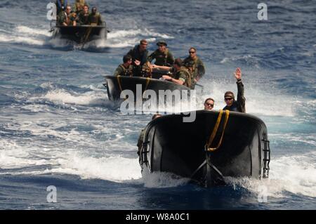 Un olandese Marine (a destra), con il Royal Netherlands Marine Corps, dirige i marinai DEGLI STATI UNITI con lo squadrone fluviale 3 durante una lungo il lato manovrare con l'olandese navi di sostegno logistico HNLMS Pelikaan (A804) nel Mare dei Caraibi a giugno 28, 2011. I marinai dal squadrone fluviale 3 erano la formazione incrociata con elementi della Royal Netherlands Marine Corps e la marina militare per tre settimane di corso di formazione progettati per familiarizzare U.S. Navy squadroni fluviale con nave olandese-to-shore le operazioni anfibie. Foto Stock