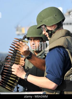 Stati Uniti Navy Petty Officer 1. Classe Eduardo Soto (sinistra) incarica il marinaio Tyler vescovo a sparare un 0,50 Caliber machine gun durante un'esercitazione a fuoco a bordo della U.S. 7 Comando della Flotta nave USS Blue Ridge (LCC 19) nel Mare della Cina del Sud il 28 marzo 2012. Foto Stock