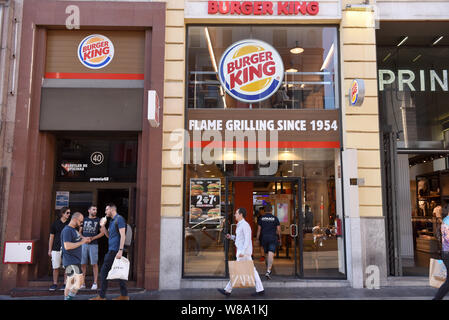 Si vedono persone camminare davanti a un Burger King store sulla Gran Via di Madrid. Foto Stock