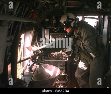 Elicottero gunner lancia Cpl. Deitrich Noblin, U.S. Marine Corps, incendi il suo .50 pistola calibro a bersagli per terra durante un live formazione antincendio volo al Shoalwater Bay Area Area Formazione nel Queensland, Australia, dal 14 ottobre, 1999. I marines stanno prendendo parte a esercitare il coccodrillo '99, di un insieme di Stati Uniti e Australia formazione militare esercizio condotti presso la Shoalwater Bay Area Formazione. Noblin è fissata per mezzo di elicottero Squadron 262. Foto Stock