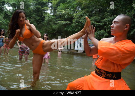 Un Cinese monaco Shaolin incarica una femmina di rafting lifeguard candidato per saperne di kungfu durante una sessione di formazione presso il Gulongxia (Gulong Gorge) raftin Foto Stock