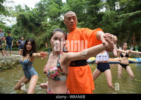 Un Cinese monaco Shaolin incarica una femmina di rafting lifeguard candidato per saperne di kungfu durante una sessione di formazione presso il Gulongxia (Gulong Gorge) raftin Foto Stock