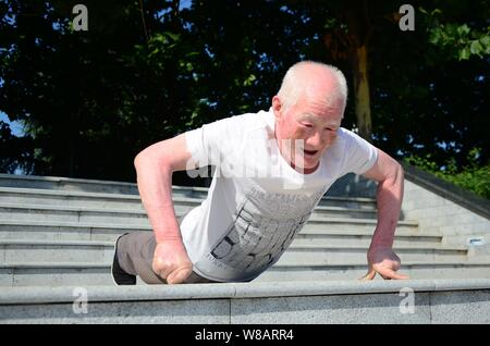 Il 79-anno-vecchio uomo cinese Zhang Zhuofu fa due-dito push-up presso un parco nella città di Xuchang, centrale cinese della provincia di Henan, 17 giugno 2016. Un anziano ma Foto Stock