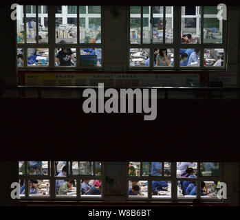 Il cinese agli studenti di esaminare i libri di testo in preparazione al prossimo collegio nazionale esame di ammissione, noto anche come gaokao, nelle loro classi all'Han Foto Stock