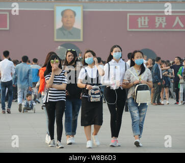 --FILE--turisti indossando maschere viso visitare la piazza Tiananmen in pesanti smog a Pechino in Cina, 30 aprile 2016. Pechino comunali sono mul Foto Stock