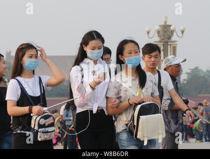 --FILE--turisti indossando maschere viso visitare la piazza Tiananmen in pesanti smog a Pechino in Cina, 30 aprile 2016. Pechino comunali sono mul Foto Stock