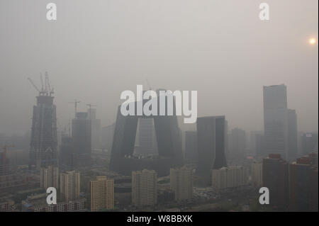 --FILE--Vista della Torre di TVCC, centro, la sede centrale di China Central Television, e altri edifici di smog pesante a Pechino in Cina, 6 aprile 201 Foto Stock