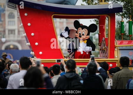 Un animatore vestito in costume di Mickey Mouse onde ai visitatori durante la sfilata di un corteo in Shanghai Disneyland a Shanghai la Disney Resort in PU Foto Stock