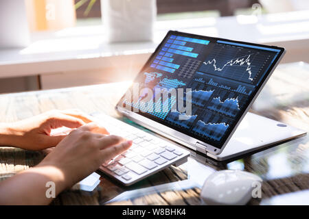 Close-up di una imprenditrice la mano analizzando il grafico su computer portatile Foto Stock