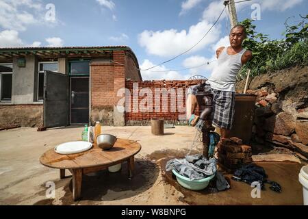 (190809) -- CHANGTU, e il Agosto 9, 2019 (Xinhua) -- Wang pista lava vestiti presso il cantiere della sua casa di Hexi villaggio di Liangjiazi Township, Changtu contea di Tieling città, a nord-est della Cina di Provincia di Liaoning, e il Agosto 8, 2019. Wang Gang, un 33-anno-vecchio abitante di Hexi villaggio della provincia di Liaoning, ha perso le sue braccia a causa di un accidentale scosse elettriche all'età di 13. Dopo anni di duro pratiche con i suoi piedi, egli non solo è in grado di prendersi cura di se stesso ma anche di fare alcune semplici faccende di casa e si prende cura dei suoi malati madre. Wang pista sono sposata con lui Xiaoman quattro anni fa e hanno avuto il loro figlio Rourou in Octobe Foto Stock