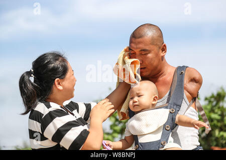 (190809) -- CHANGTU, e il Agosto 9, 2019 (Xinhua) -- egli Xiaoman, moglie di Wang Gang, salviette per il sudore Wang pista a Hexi villaggio di Liangjiazi Township, Changtu contea di Tieling città, a nord-est della Cina di Provincia di Liaoning, e il Agosto 8, 2019. Wang Gang, un 33-anno-vecchio abitante di Hexi villaggio della provincia di Liaoning, ha perso le sue braccia a causa di un accidentale scosse elettriche all'età di 13. Dopo anni di duro pratiche con i suoi piedi, egli non solo è in grado di prendersi cura di se stesso ma anche di fare alcune semplici faccende di casa e si prende cura dei suoi malati madre. Wang pista sono sposata con lui Xiaoman quattro anni fa e hanno avuto il loro figlio Rourou in Foto Stock