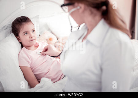 Professional smart terapista femmina usando il suo stetoscopio Foto Stock