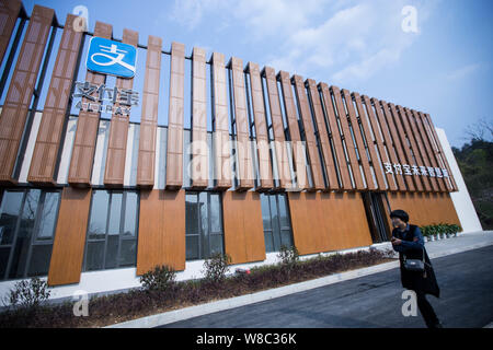 --FILE--un pedone cammina davanti a un edificio con un logo di cinesi e-commerce giant Alibaba Group al Alipay Smart City nella contea di Anji, Huzhou city, Foto Stock