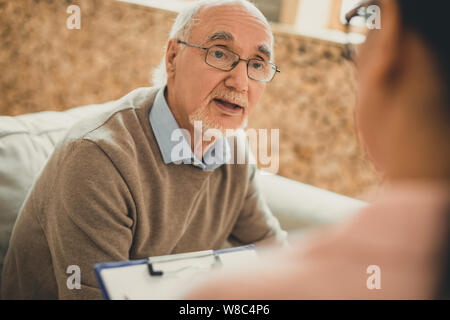 Esaurito il senior con la barba bianca chiedendo il suo volontario Foto Stock