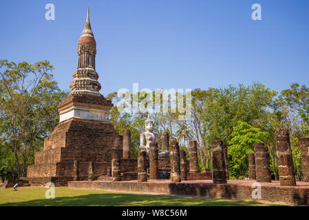 Scultura di Budda seduto sulle rovine di un antico tempio buddista nel parco storico di Sukhothai. Della Thailandia Foto Stock