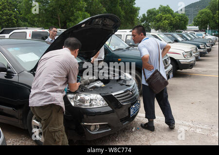 --FILE--le persone guardano al governo vetture prima che vengano messe all'asta nella città di Shenzhen, sud Chinas nella provincia di Guangdong, 19 giugno 2014. Il primo lotto di Foto Stock