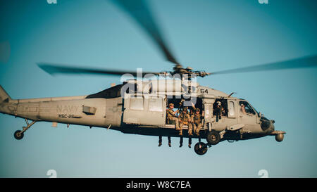 190726-M-HB658-1020 GOLFO ARABICO (26 luglio 2019) Costa guardie con la sicurezza marittima la risposta del team di Oriente, Advanced Team di interdizione del distacco 1, volare in un un MH-60S Sea Hawk con elicottero mare squadrone di combattimento (HSC) 26 durante una visita congiunta, scheda, ricerca e sequestro di esercitare con il raid marittimo vigore, undicesimo Marine Expeditionary Unit (MEU). Il Boxer anfibio gruppo pronto e la XI MEU sono distribuiti negli Stati Uniti Quinta Flotta area di operazioni a sostegno di operazioni navali per garantire stabilità marittimo e la sicurezza nella regione centrale di collegamento del Mediterraneo e del Pacifico attraverso Foto Stock