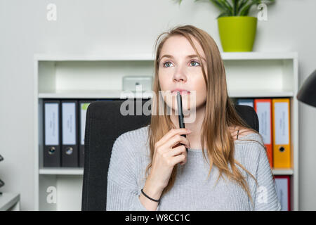 Giovane donna in ufficio ha un ispirazione Foto Stock
