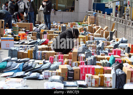 --FILE--studenti cinesi cerca in una massa di pacchi, la maggior parte dei quali sono da shopping online, di fronte a un cancello di Minzu università di Cina a Beiji Foto Stock