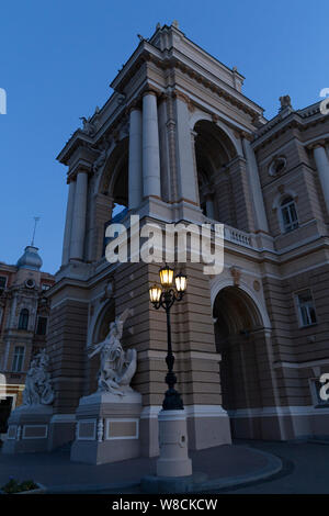 Ucraina Odessa, Lanzheronivska street, 13 giugno 2019. L'arco di entrata del palazzo dell'opera all'alba con un grande angelo scultura. Foto Stock