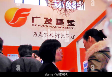 --FILE--dipendenti cinesi parla con i visitatori allo stand di GF Fund Management durante una mostra a Shanghai in Cina, 22 novembre 2009. Nasdaq OMX Foto Stock