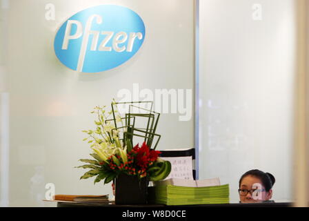 --FILE--un dipendente cinese lavora alla reception della sede di Shanghai di Pfizer in Cina a Shanghai, 23 luglio 2013. Pfizer Inc. è quello di fermare la sua va Foto Stock