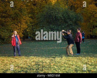 Mosca, Russia - 11 Ottobre 2018: turisti cinesi passeggiate parco d'autunno. Anziani popoli asiatici scattare foto sullo sfondo di una bella ingiallito Foto Stock