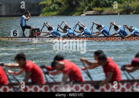 I partecipanti competono in una gara di dragon boat sulle rive di un fiume in Macau, Cina, 20 giugno 2015. Dragon Boat gare si sono svolte in Cina per celebrare il tradi Foto Stock