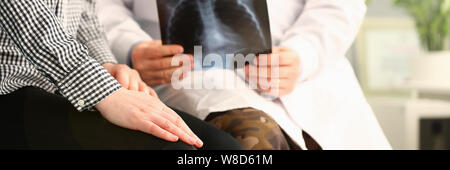 Medico paziente tiene x-ray e relazioni cattive notizie Foto Stock