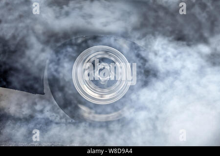 Drag racing auto gomma brucia fuori i suoi pneumatici in preparazione per la gara Foto Stock