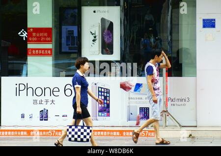 --FILE--pedoni a piedi passato la pubblicità per Apple iPhone 6 in smartphone Yichang city, centrale cinese della provincia di Hubei, 22 luglio 2015. Mele Foto Stock