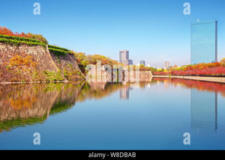 Paesaggio autunnale e moderni edifici intorno al fiume fossato del castello di Osaka Osaka in Giappone Foto Stock