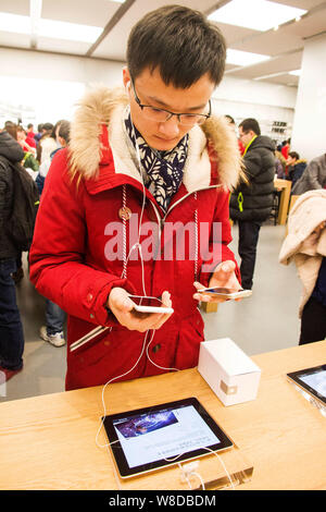 Un cliente cinese tenta di eseguire l'iPhone 6 e 6 smartphone Plus presso l'Apple Store al MIX MIX (Città) centro commerciale per lo shopping nella città di Zhengzhou, la Cina centrale' Foto Stock