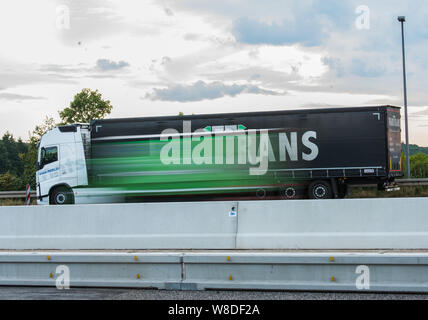 08 agosto 2019, Assia, Ober-Mörlen: un camion parchi all'uscita della Wetterau Ovest area di servizio. Hesse autostrade della mancanza di centinaia di camion di spazi di parcheggio. Truck driver quindi girare per arresto di emergenza o di alloggiamenti per le entrate e le uscite al fine di park e a rispettare i loro periodi di riposo. (A dpa messaggio 'Carrello spazi di parcheggio sulle autostrade regolarmente sovraccaricato') Foto: Andreas Arnold/dpa Foto Stock