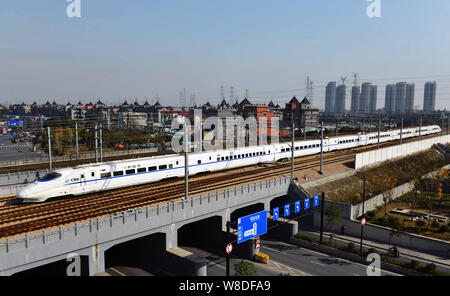 --FILE--un CRH (Cina ferrovia ad alta velocità) bullet train viaggia sulle piste in Hangzhou, est Chinas nella provincia di Zhejiang, 30 dicembre 2014. Enti locali Foto Stock