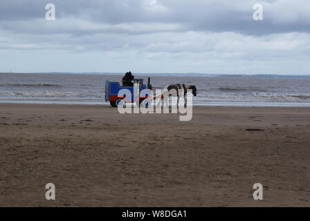 A Thomas Il serbatoio del motore di treno essendo trascinato da un pony su Weston-Super-Mare spiaggia Foto Stock