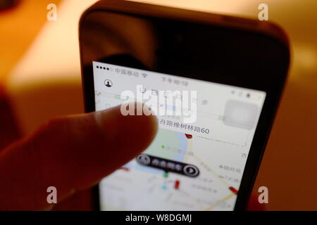 --FILE--un uomo utilizza il taxi-salutando app Uber sul suo smartphone di Chengdu, a sud-ovest della Cina di provincia di Sichuan, 24 marzo 2015. Taxi app Uber ha Foto Stock