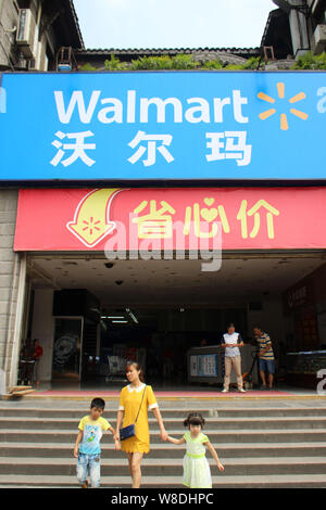 --FILE--i clienti lasciano un supermercato Walmart a Chongqing Cina, 12 agosto 2015. Wal-Mart Stores Inc è in cerca di riduzioni di prezzo da parte dei fornitori che p Foto Stock