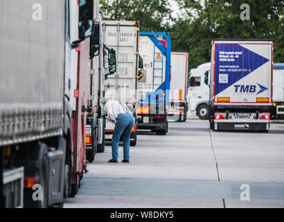 08 agosto 2019, Assia, Ober-Mörlen: un camionista grill accanto al suo veicolo di Wetterau Ost area di servizio. Hesse autostrade della mancanza di centinaia di camion di spazi di parcheggio. Truck driver quindi girare per arresto di emergenza o di alloggiamenti per le entrate e le uscite al fine di park e a rispettare i loro periodi di riposo. Foto: Andreas Arnold/dpa Foto Stock