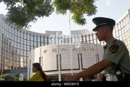 --FILE--un cinese di paramilitari poliziotto passeggiate oltre la sede e sede della Banca Popolare di Cina (PBOC), la Cina della banca centrale, in essere Foto Stock