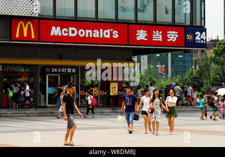 --FILE--pedoni a piedi passato un McDonald un fast food ristorante a Chongqing Cina, 25 luglio 2015. La Cina è il più grande mercato per Yum e casa Foto Stock